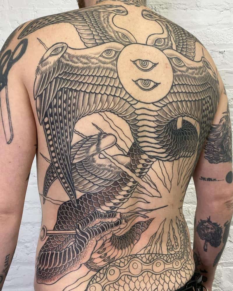 Tattoo of a creature with wings and a snake tail with ten eyes