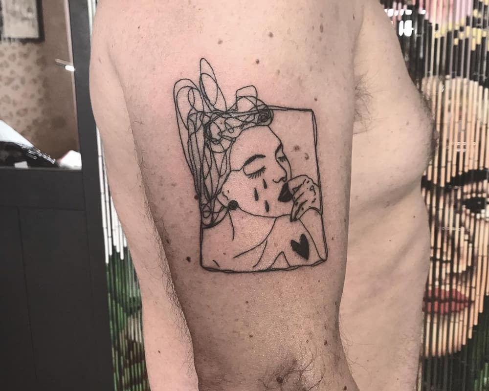 Tattoo of a crying girl with a heart on her shoulder