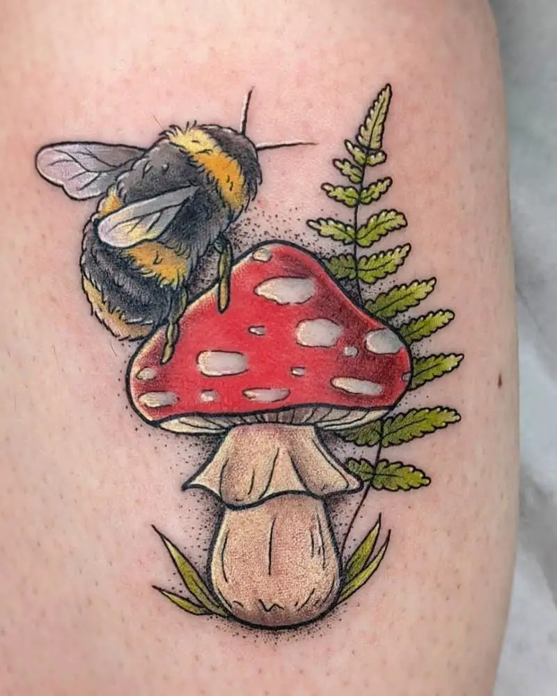 Tattoo of a mushroom with a bumblebee sitting on it