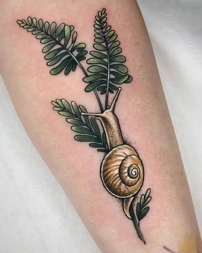 Tattoo of a snail crawling on a pla