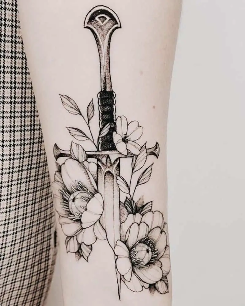 Tattoo of a sword hilt in flowers