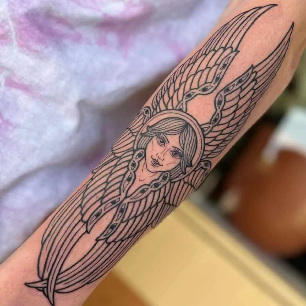 Tattoo of an angel with six wings with eyes and a smiling woman's face