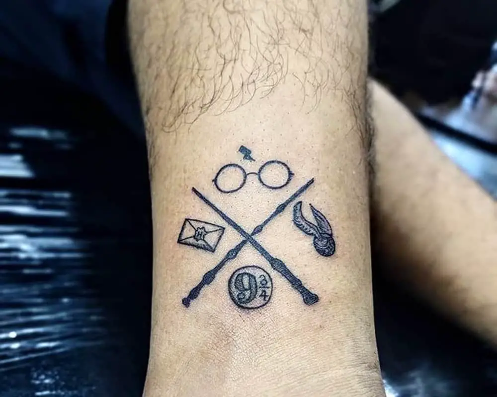 Tattoo of crossed wands, glasses, gold snitch, letter and 9 3/4