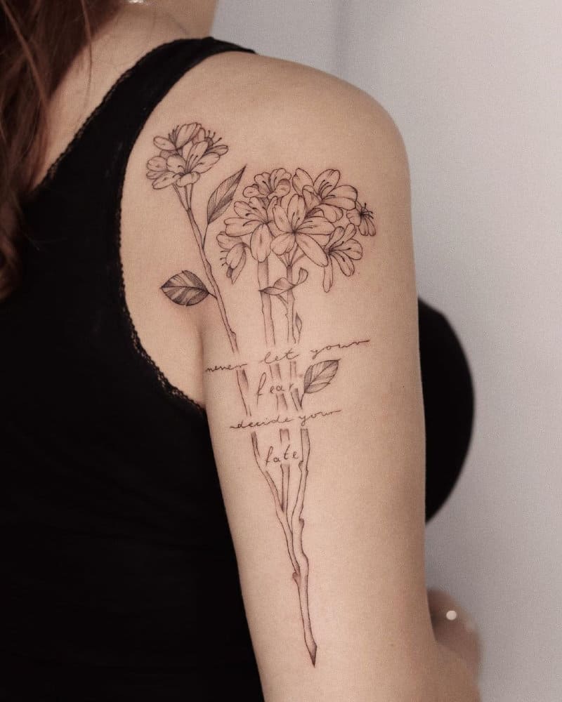 Tattoos in the form of a branch of flowers on the shoulder