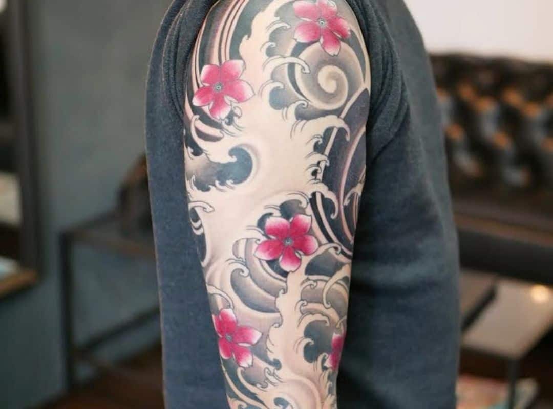 Flowers and waves arm tattoo