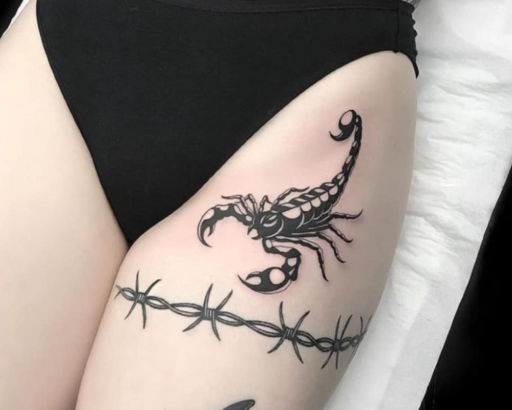 a scorpion tattoo on a girl's thigh