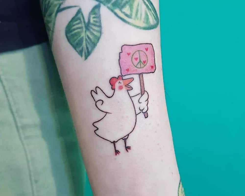 a small tattoo in the shape of a chicken with a poster of peace