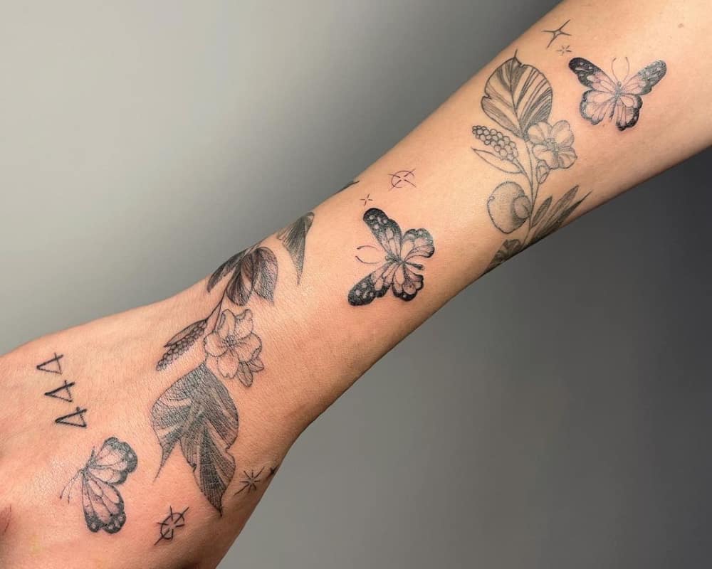 a tattoo in the form of a bracelet with a branch of a plant and butterflies