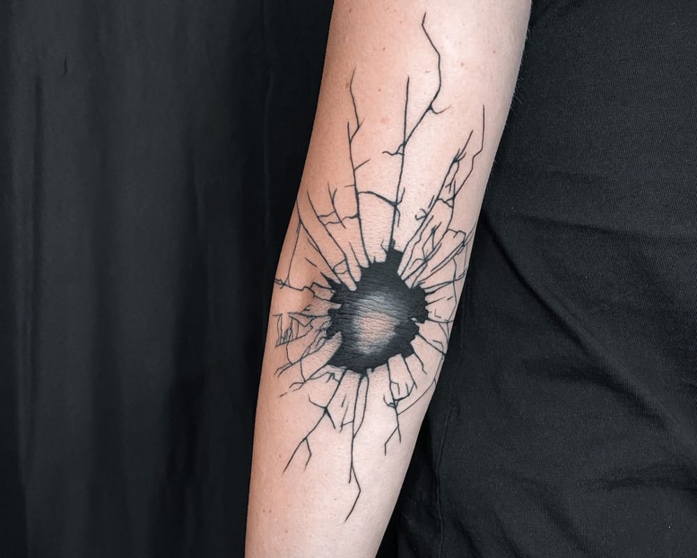 a tattoo in the form of a broken skin on the elbow