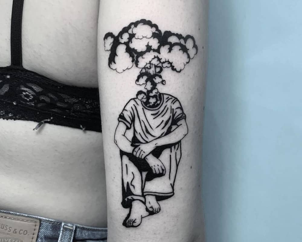 a tattoo in the form of a sitting silhouette with an explosion instead of a head