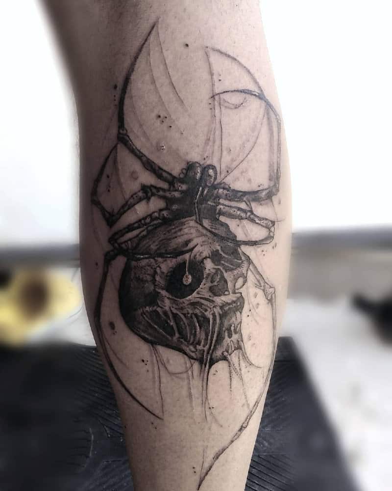 a tattoo in the shape of a horrible skull with a spider