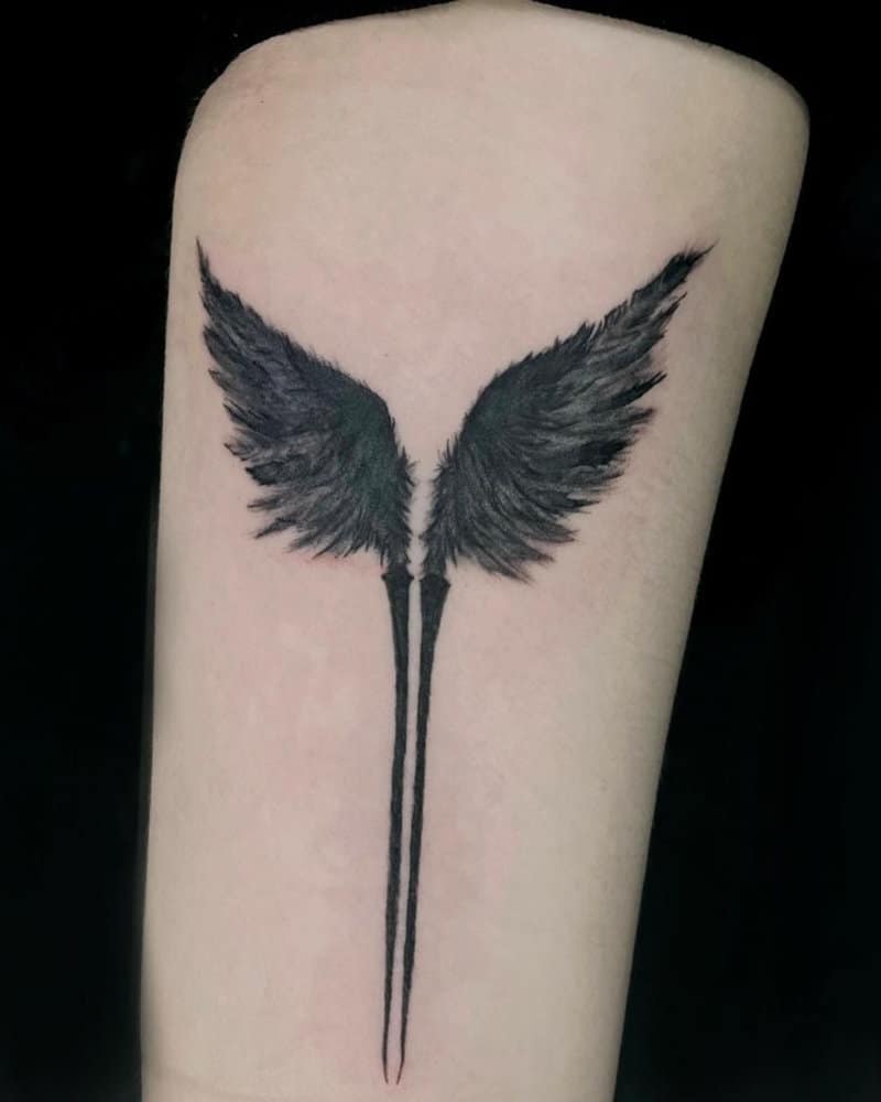 a tattoo in the shape of two black wings