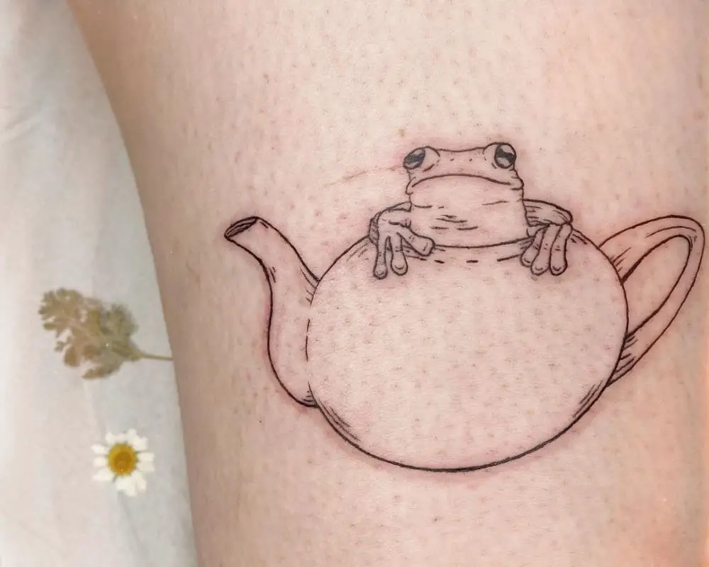 a tattoo of a kettle with a frog coming out of it
