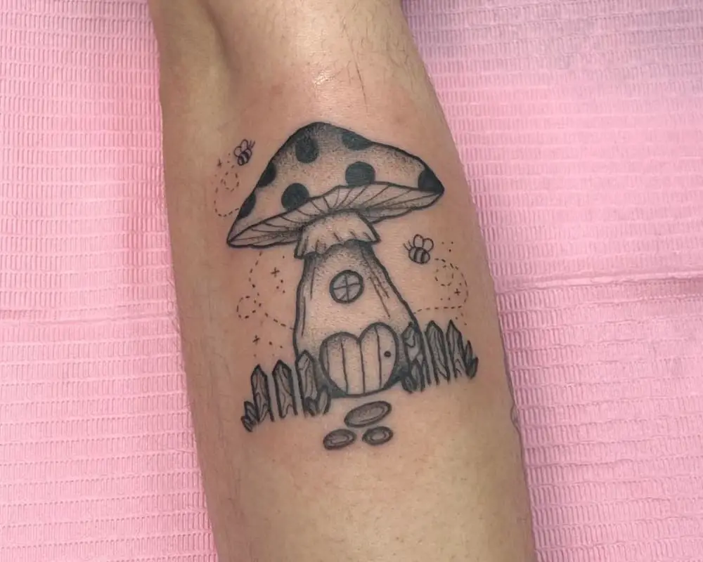 a tattoo of a mushroom house with a fence