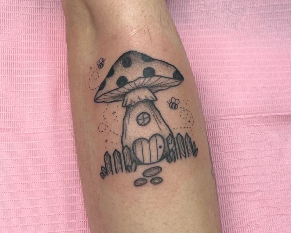 a tattoo of a mushroom house with a fence