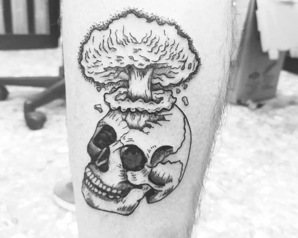 a tattoo of a skull with a large mushroom from an explosion in the forehead