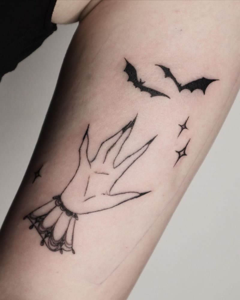 a tattoo of a vampire arm and two bats