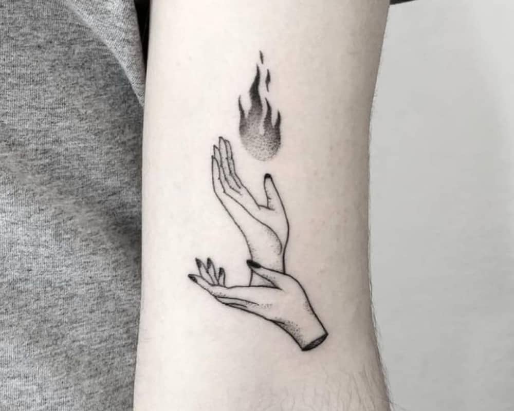 a tattoo of two hands and a fire