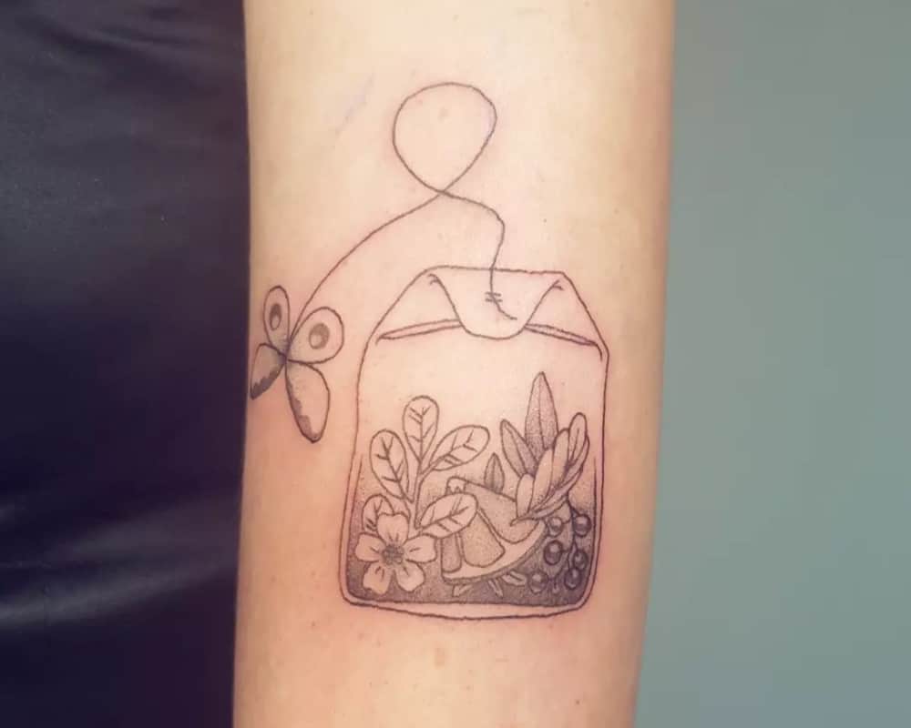 a tea bag tattoo with flowers and fruit inside