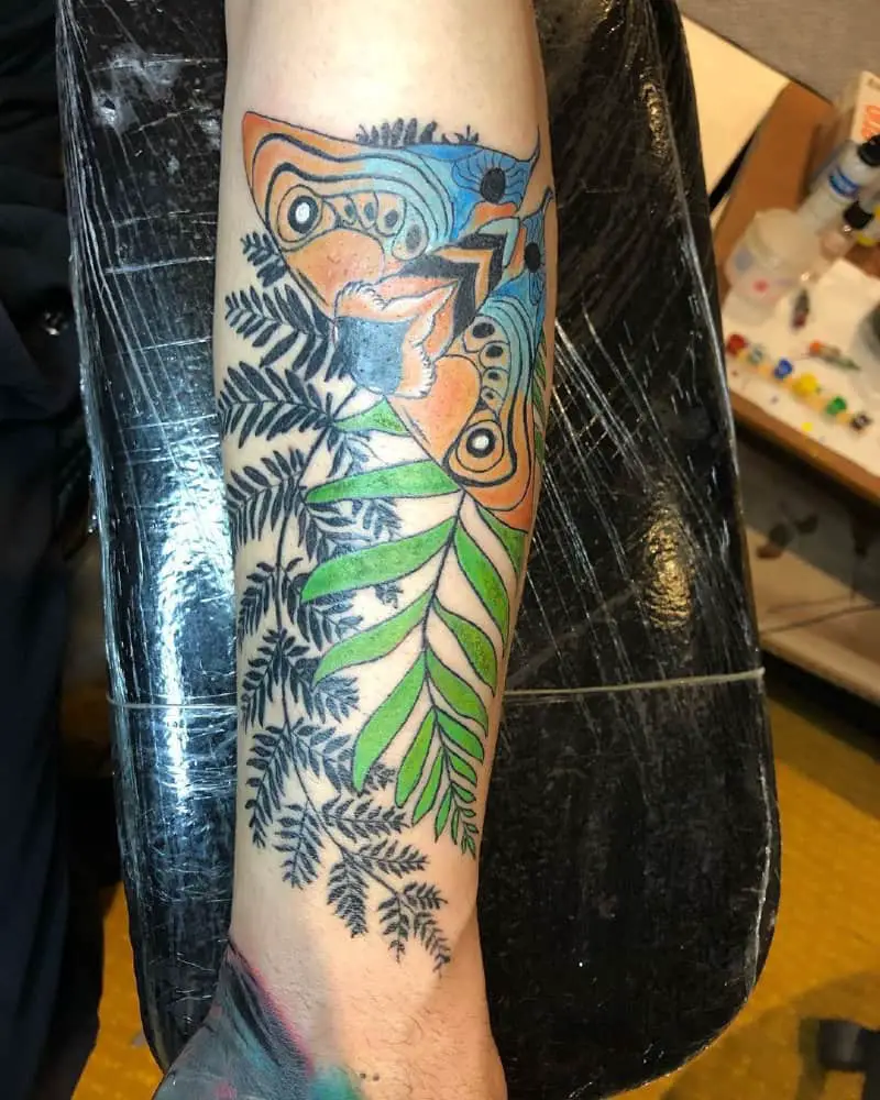 colored tattoo of a cicada on plants