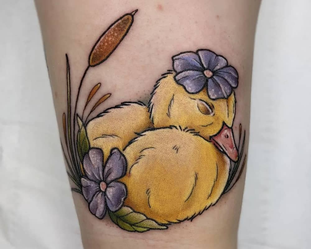 coloured tattoo of a duckling with a flower on his head