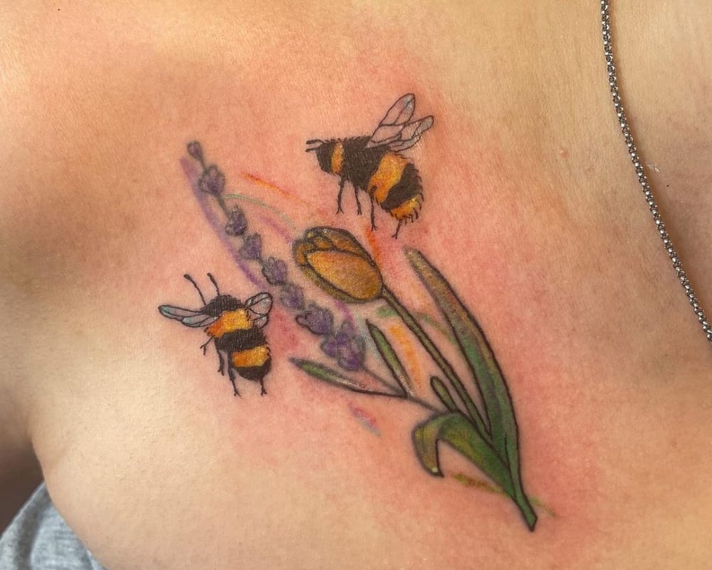 coloured tattoo of flowers and two bumblebees