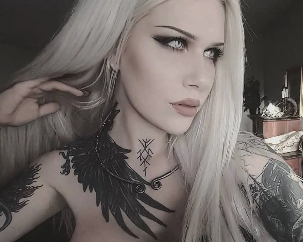 girl with a black raven tattoo on her neck and runes