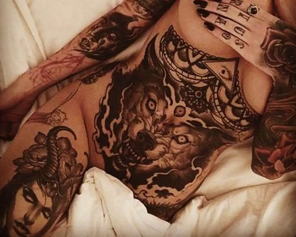 many tattoos on a woman's body with a big wolf on her belly, and lots of detail