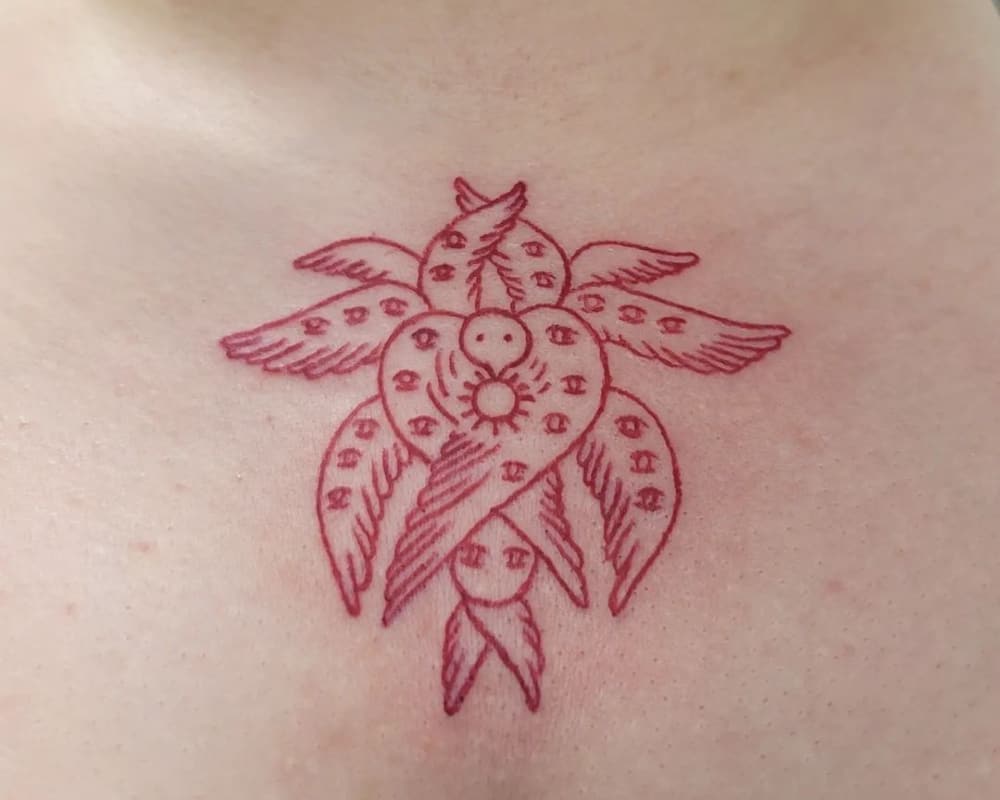 red minimalist tattoo in the form of wings with eyes