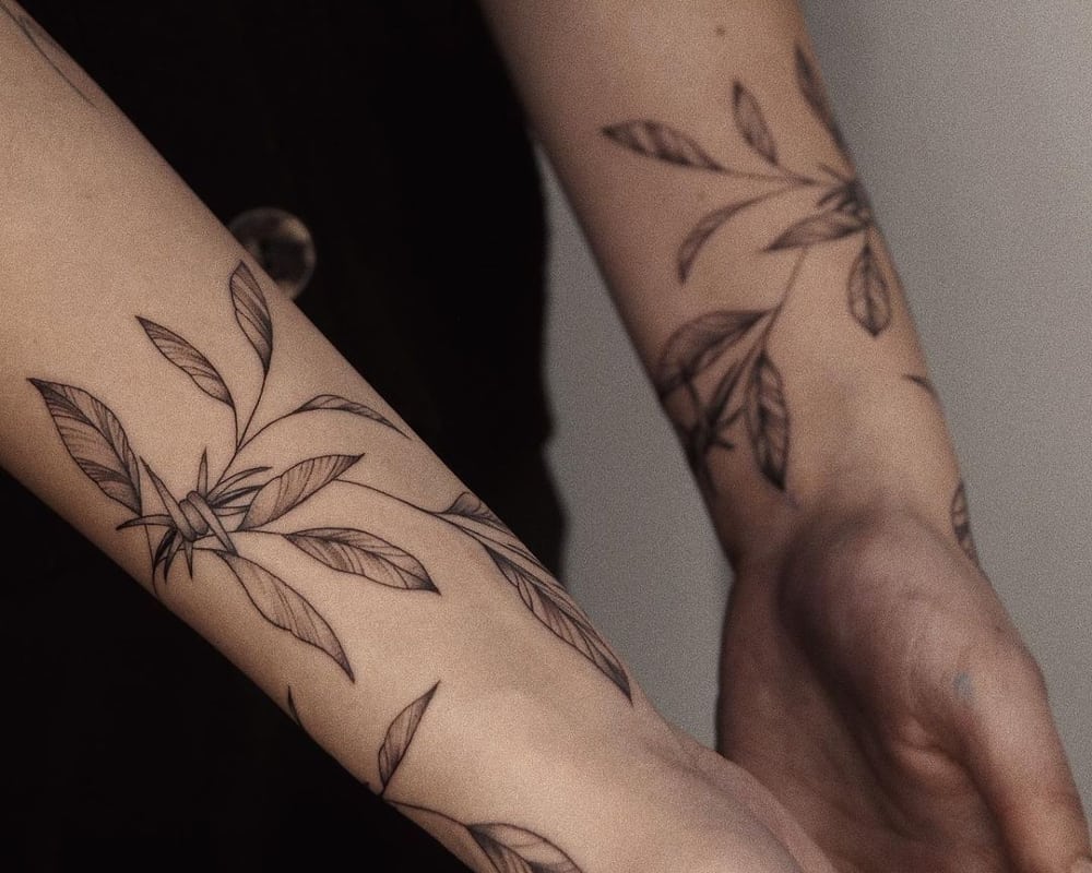 tattoo in the form of a bracelet with leaves and barbed wire