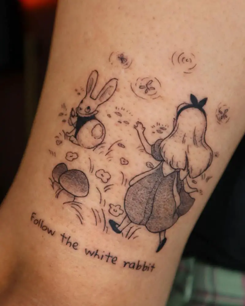 tattoo of Alice with a rabbit and the words Follow the white rabbit