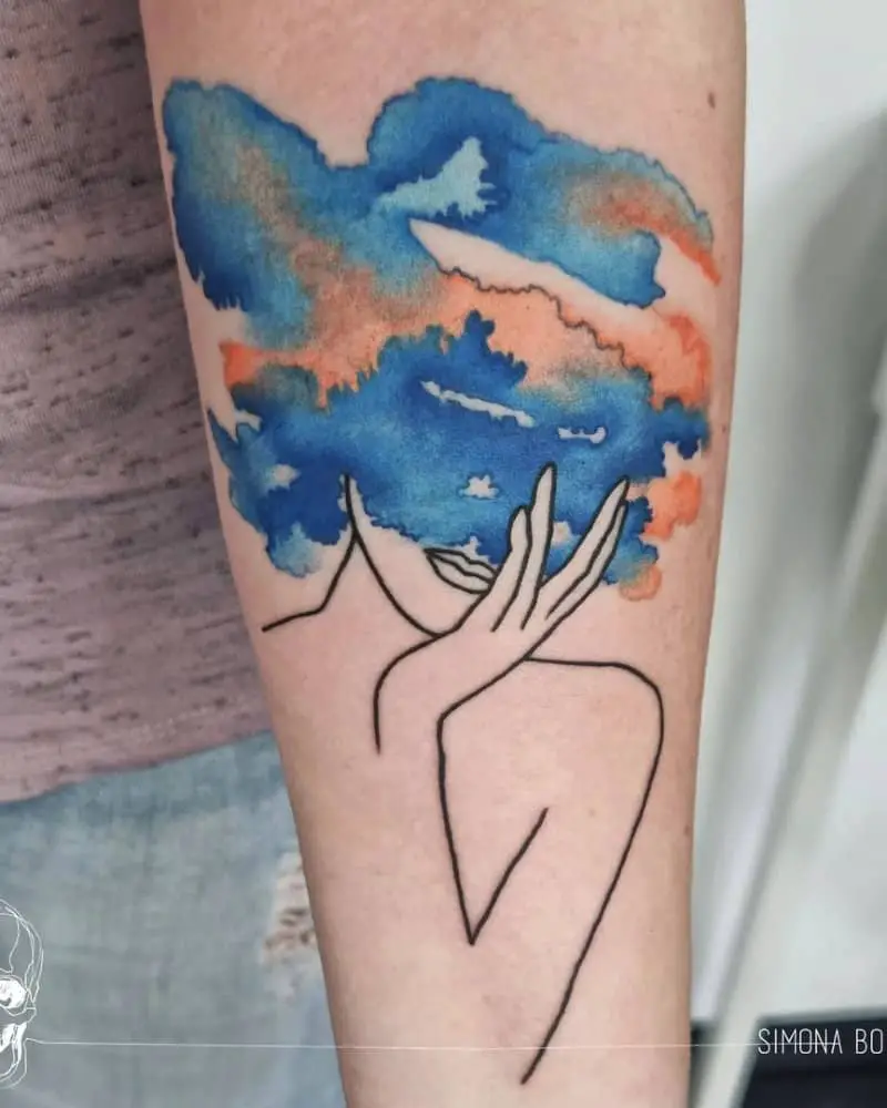 tattoo of a female silhouette in colored clouds