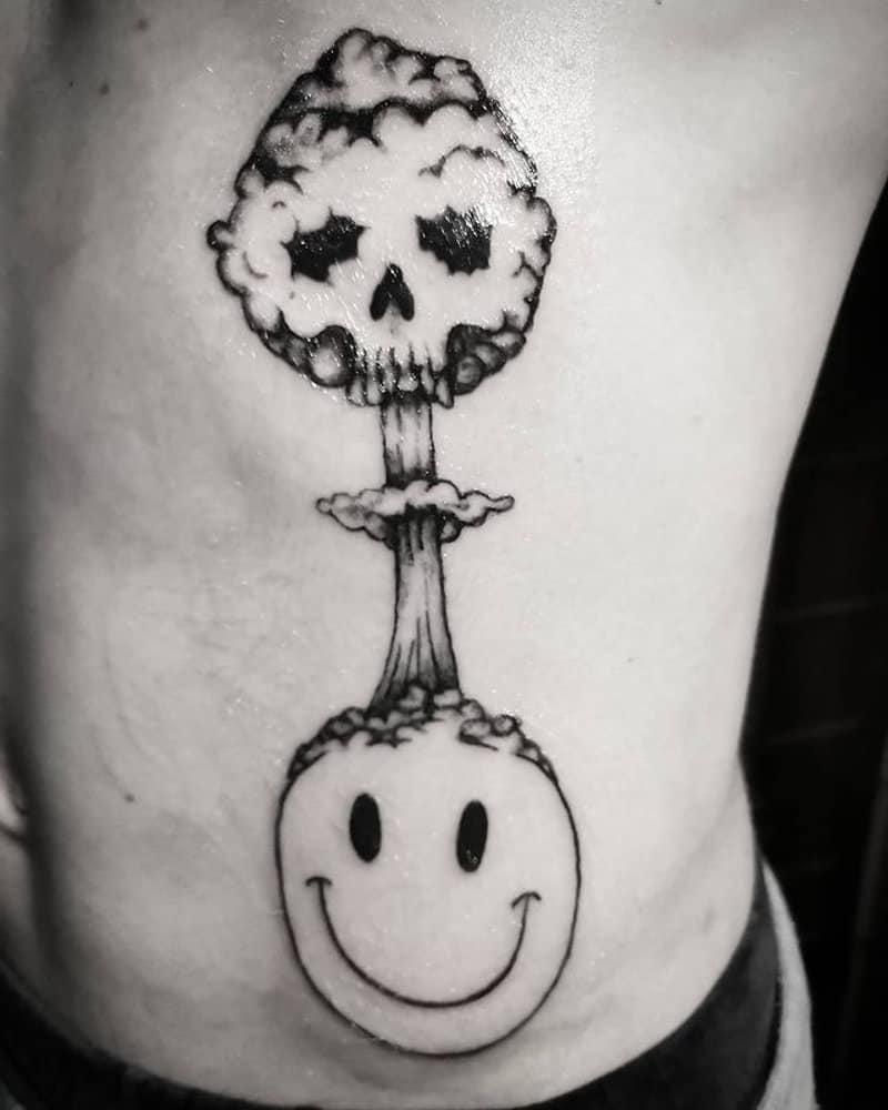 tattoo of a smiling smiley with a bursting head in the shape of a skull