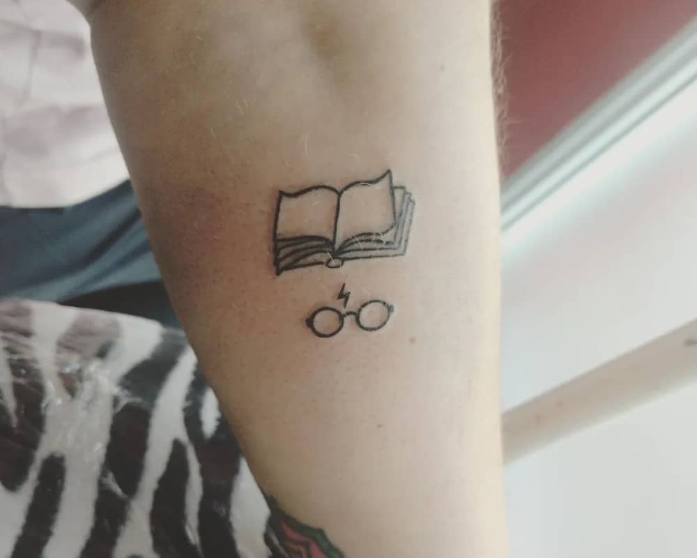 tattoo of an open book and glasses