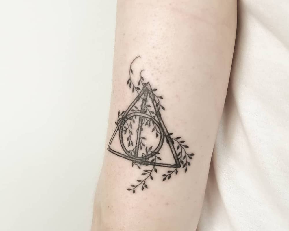 tattoo of the Deathly Hallows symbol braided with vines