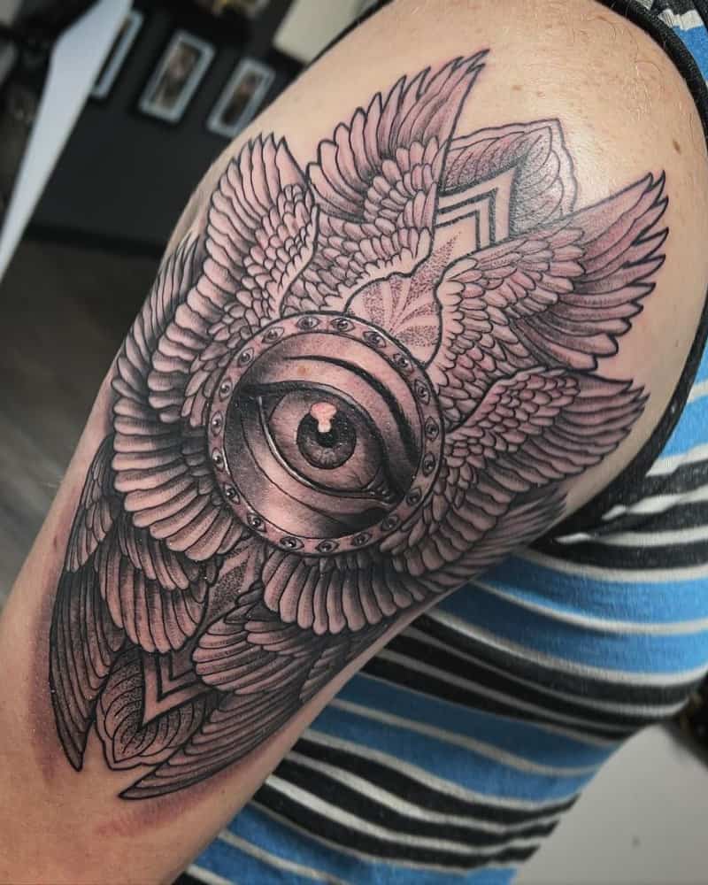 tattoo of wings and ring with eyes and one eye in the centre