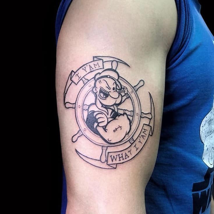 A black and white tattoo of a Popeye sailor tattooed on his shoulder