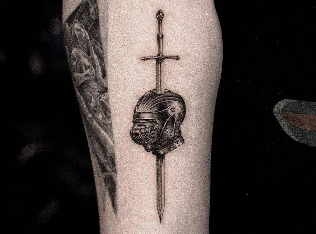 A tattoo of a helmet pierced by a sword