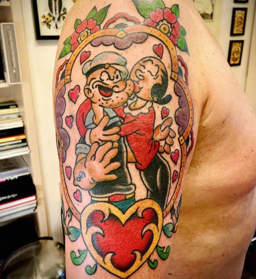 A tattoo of a Popeye sailor being kissed by a girl