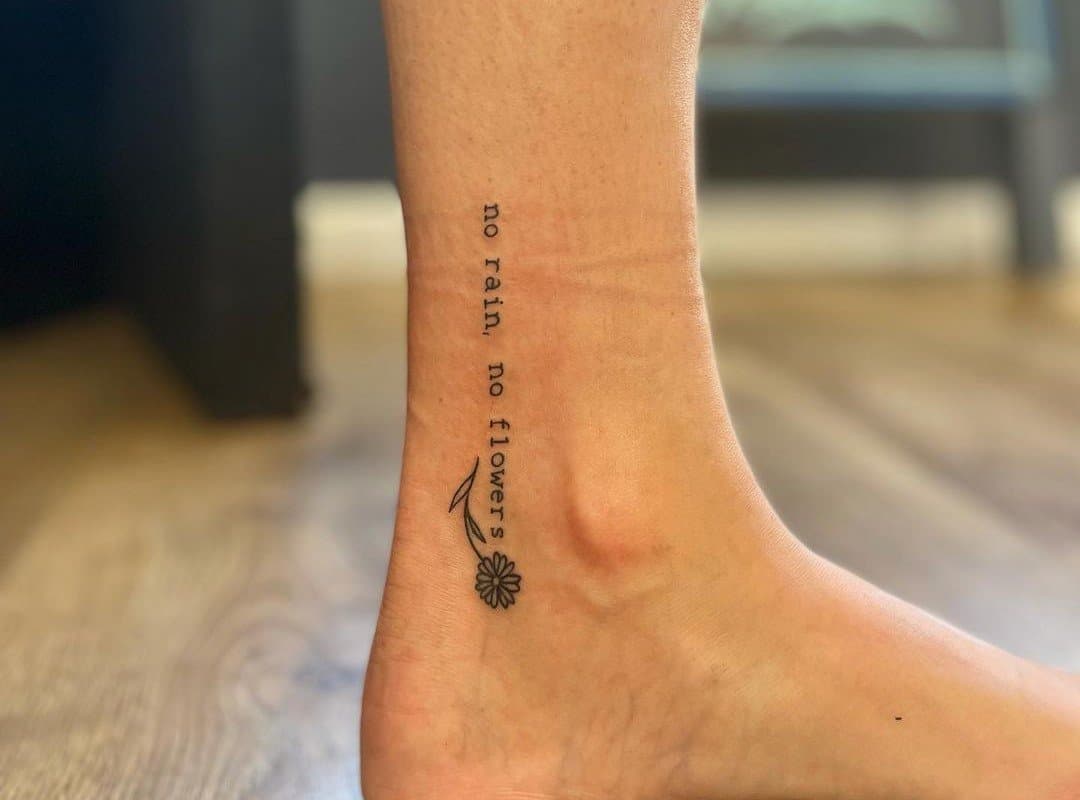 "no rain no flowers" tattoo on foot