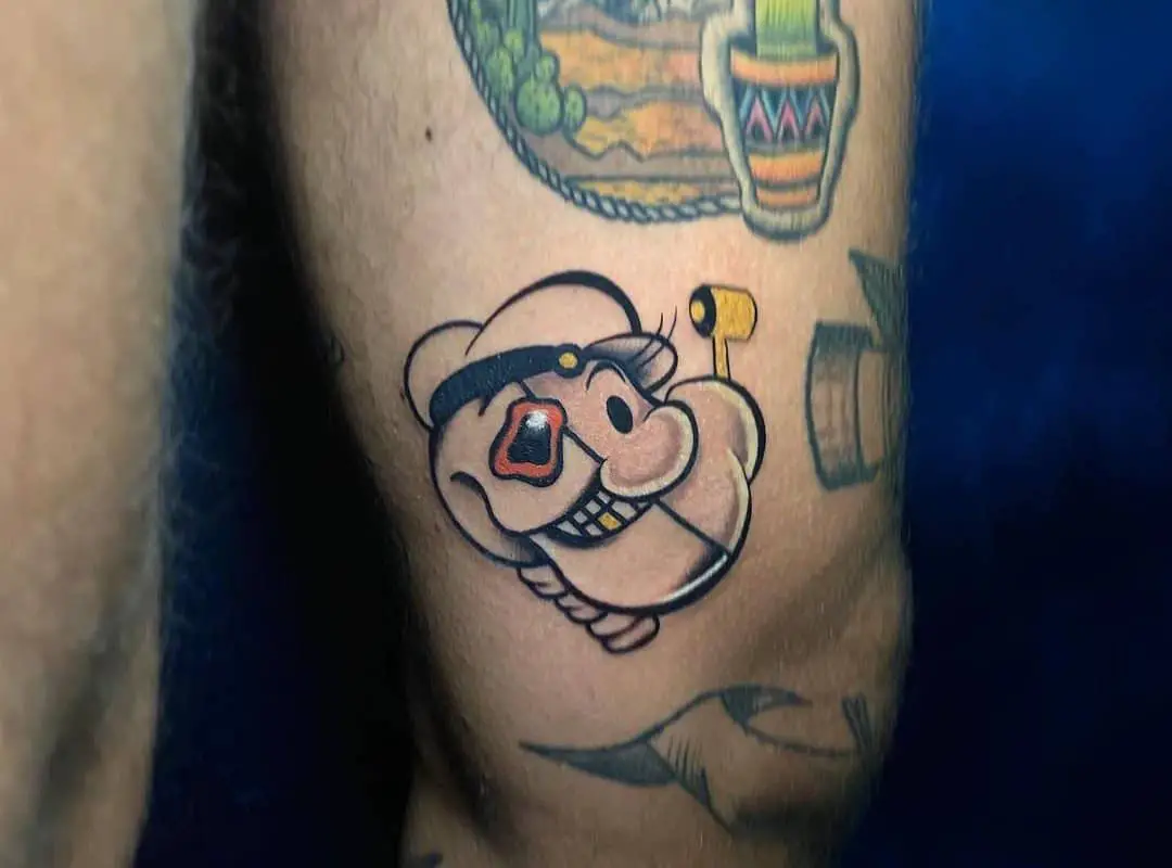 Popeye sailor head tattoo on inner thigh