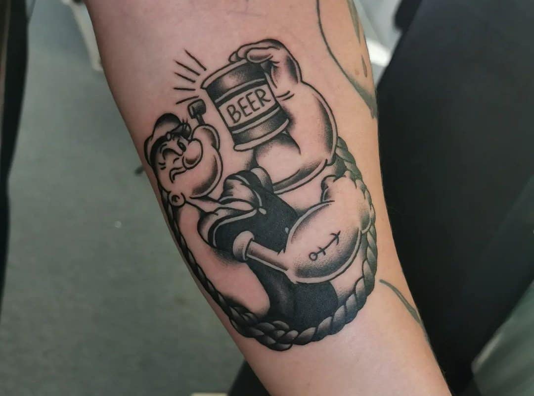 a sailor's tattoo of a popeye holding a can of beer