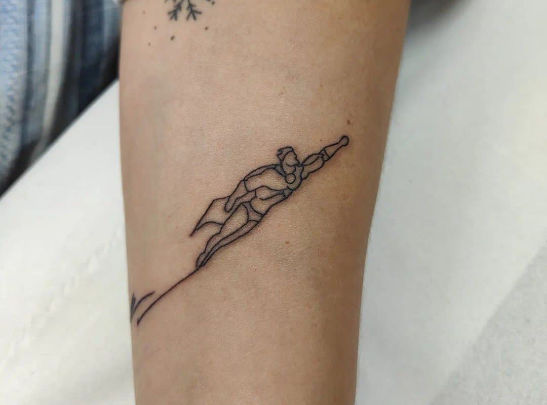 minimalist tattoo of Superman on the arm