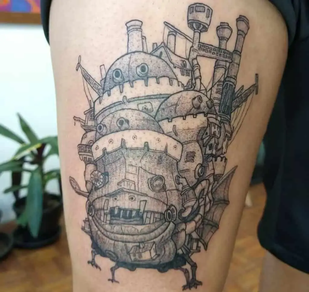 black and white tattoo of howl's moving castle on the thigh