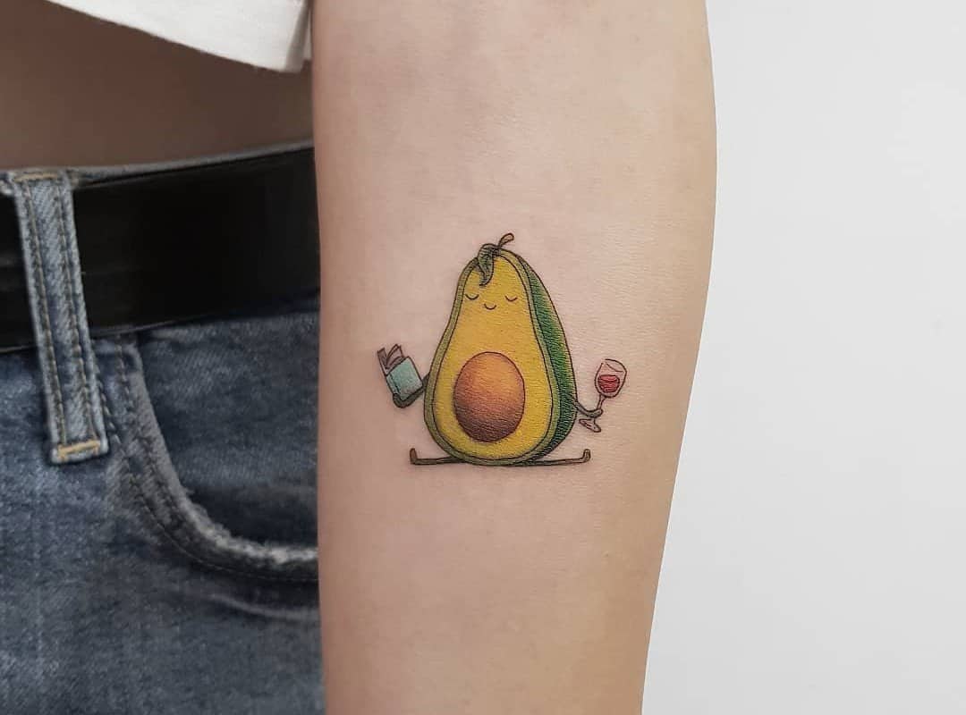 Avocado tattoo with a book and a glass