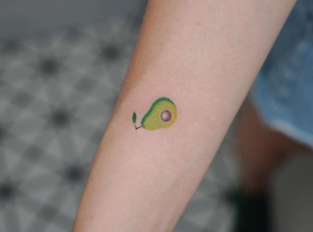 small avocado tattoo with a leaf