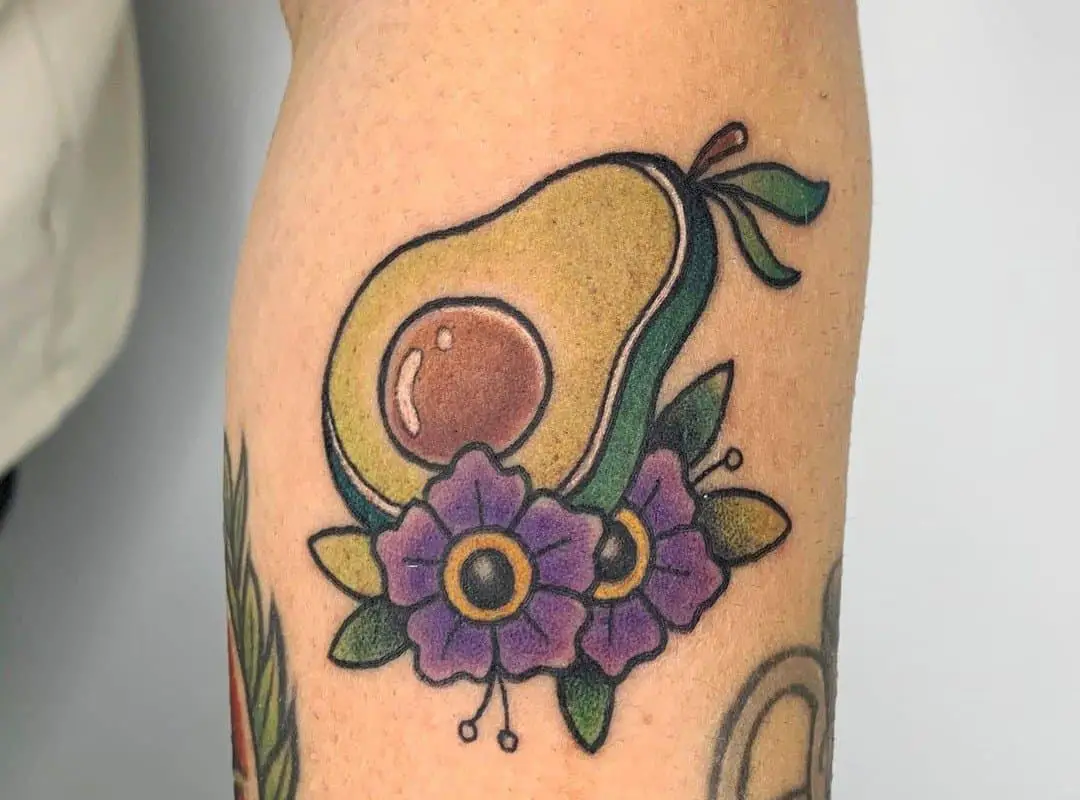 avocado-tattoo with purple flowers on the hand