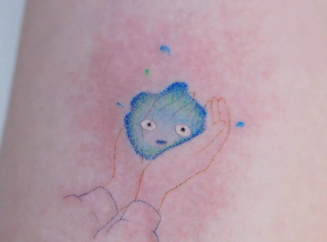 Blue Calcifer tattooed in the arm