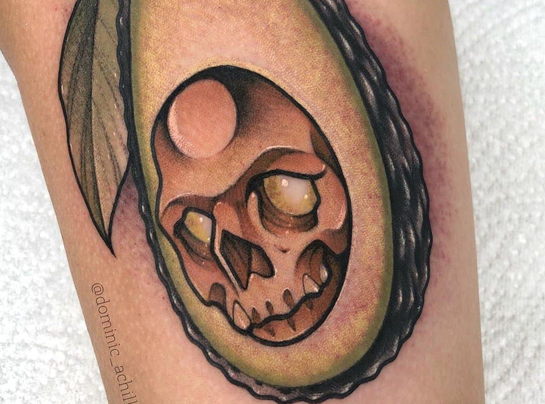 Brutal avocado tattoo with a skull on his arm