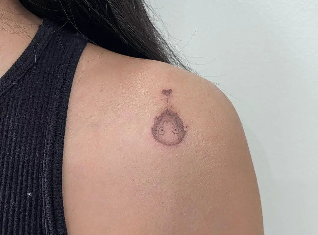 a small tattoo of a calcifer on the shoulder